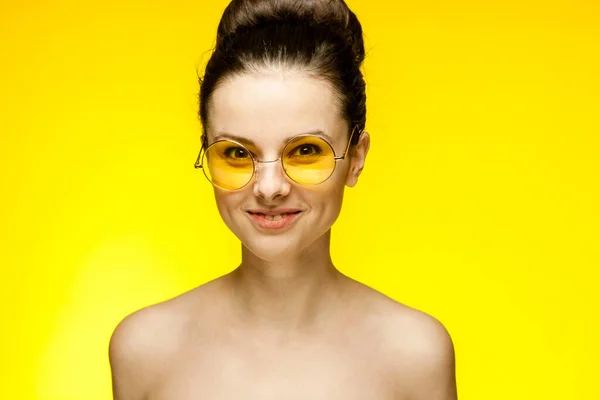 Çıplak omuzlu, sarı gözlüklü bir kadın. — Stok fotoğraf
