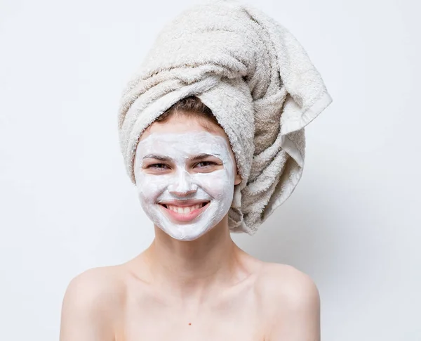 Wanita cantik perawatan masker wajah putih dan handuk di kepala — Stok Foto