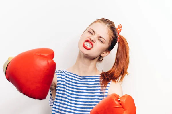 Femme boxe sur un fond clair gants rouges sport t-shirt rayé — Photo