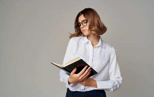 Zakelijke vrouw met een notebook in haar handen en bril op haar gezicht — Stockfoto