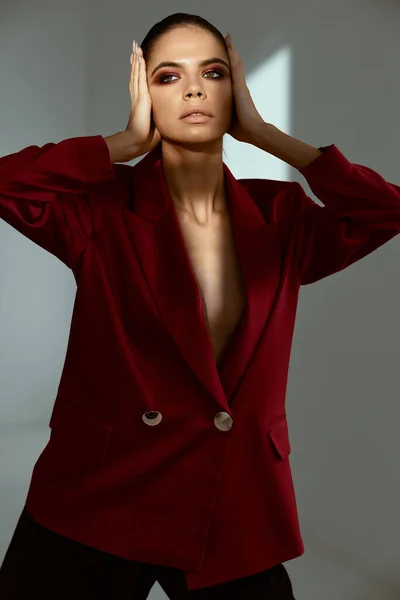 Bonita mujer sosteniendo la cara cosméticos chaqueta roja modelo — Foto de Stock