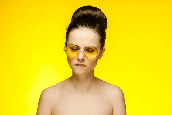 Morena con hombros desnudos con gafas amarillas recortadas ver aislado fondo emoción moda — Foto de Stock