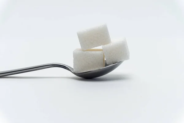Cubes de sucre dans une cuillère à café de bonbons ingrédient calorique Glucose — Photo