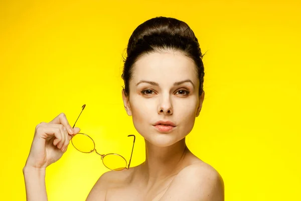 Brünette mit nackten Schultern gelbe Modebrille Emotionen isolierten Hintergrund — Stockfoto