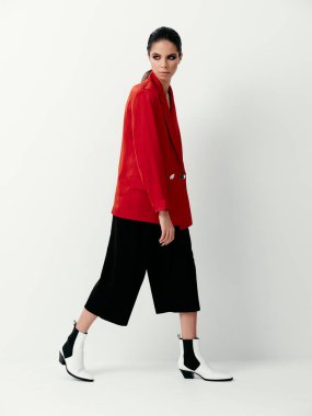 Güzel esmer, kırmızı ceketli stüdyo giysi reklamı modası.