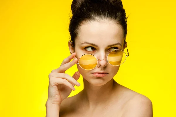 Брюнетка с голыми плечами в желтых очках обрезанный вид — стоковое фото