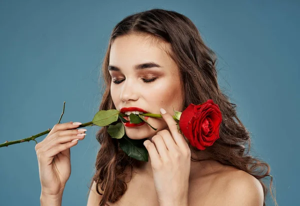 Donna con una rosa nei denti sera trucco blu modello di sfondo — Foto Stock