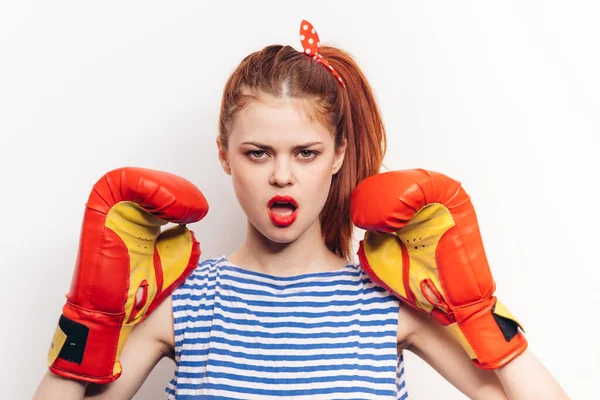 Femme surprise en gants de boxe sur un fond clair rayé t-shirt coiffure maquillage — Photo