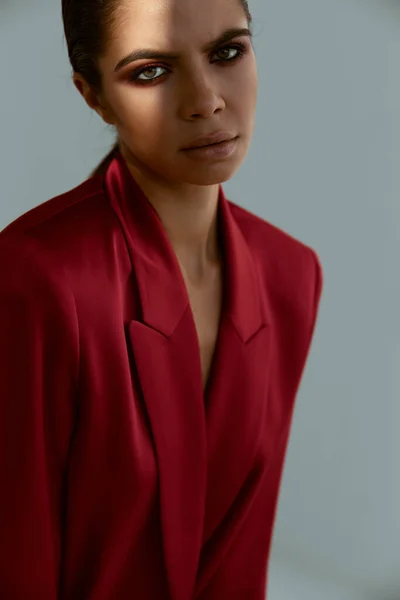 Brunette tenant sa main au-dessus de sa tête veste rouge décoration studio de mode — Photo