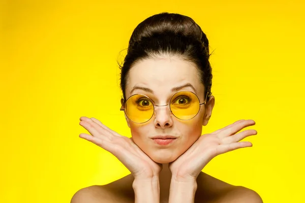 Bruna con spalle nude occhiali gialli emozioni ritagliato vista studio — Foto Stock