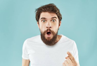 Mavi arkaplan portresi modeli üzerinde beyaz tişörtlü adamın kırpılmış görüntüsü