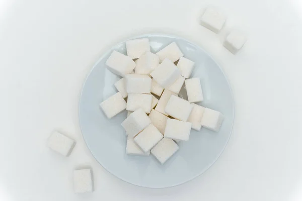 Geraffineerde suikerklontjes op een bord energiecalorieën — Stockfoto