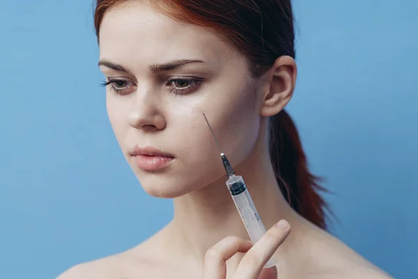 Les femmes font des injections au visage sur une seringue de fond bleue changement d'apparence du vaccin — Photo