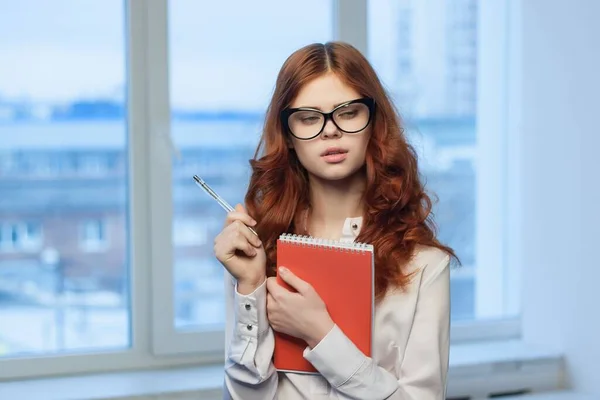 Femme d'affaires avec un bloc-notes rouge dans les mains d'un gestionnaire professionnel des finances — Photo