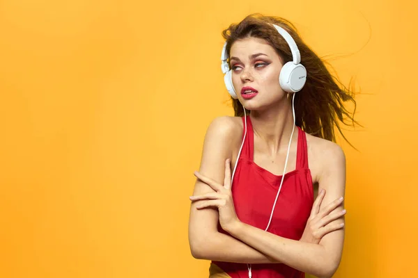 Mulher emocional em fones de ouvido brancos escuta música divertida estilo de vida fundo amarelo — Fotografia de Stock