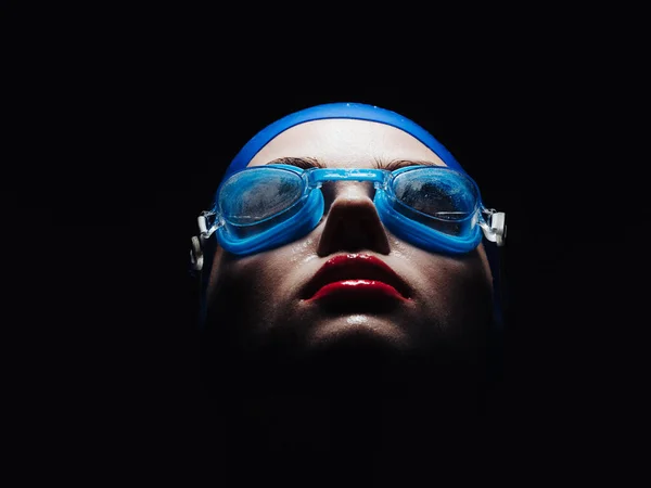 Sportswoman on a black background in goggles for swimming portrait close-up — Stock Photo, Image