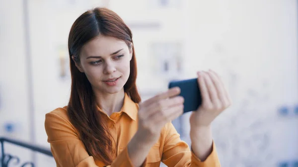 Elinde telefon olan güzel bir kadın. Açık hava fotoğraf teknolojisi. — Stok fotoğraf