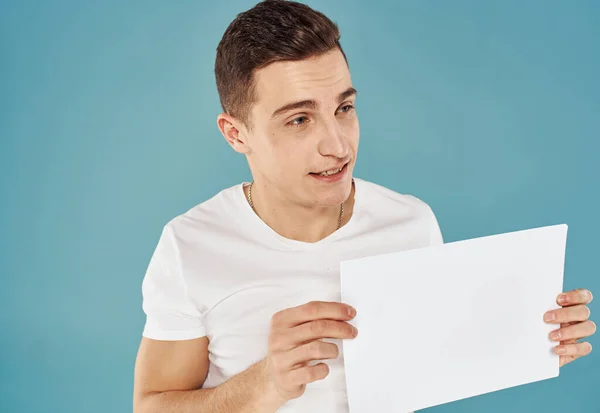 Homme avec flyer à la main et maquette fond bleu vue recadrée — Photo