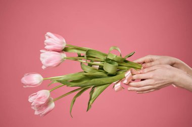 Bir buket çiçek ellerinde pembe arka plan hediye günü