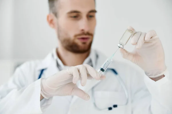Läkare i en medicinsk klänning håller en spruta i handen och en vaccininjektion. — Stockfoto
