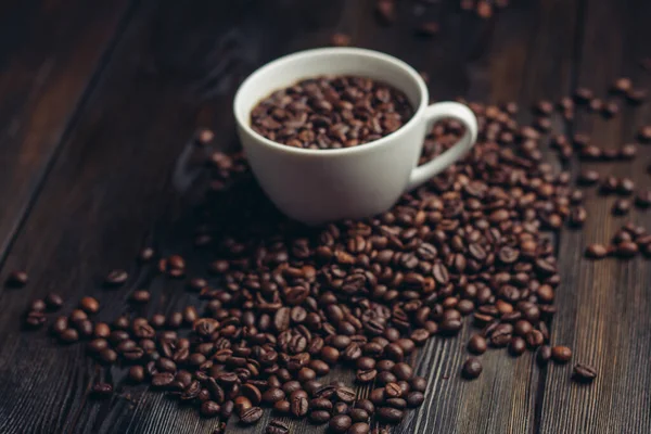 Filiżanka i spodek ziarna kawy na drewnianym tle aromat — Zdjęcie stockowe