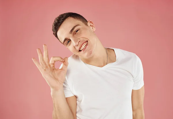 Lindo hombre y blanco camiseta mano gesto emociones rosa fondo —  Fotos de Stock