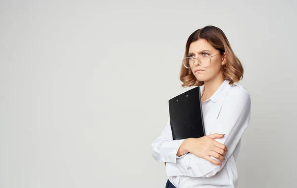 Donna d'affari in una camicia e occhiali su uno sfondo leggero con documenti in mano — Foto Stock