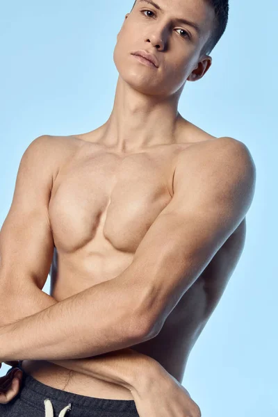 Wysportowany mężczyzna z muskularnym trening ciała sportowiec niebieskie tło — Zdjęcie stockowe