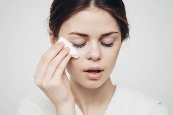 Mujer se limpia la cara con un modelo de cuidado de belleza esponja suave blanca — Foto de Stock
