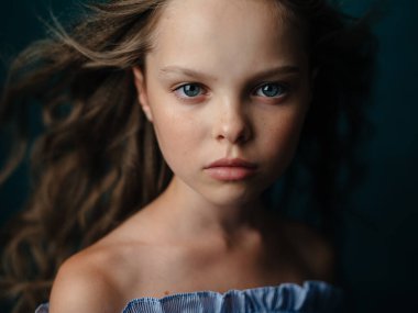 Koyu arkaplanda güzel bir kız bebek, yakın plan kesilmiş bir portre.