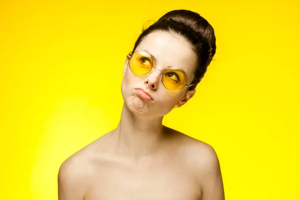 Brunett med bara axlar gult mode glasögon känslor — Stockfoto