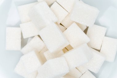 Bir tabak tatlı üzerinde granüle şeker küpleri hafif arka plan