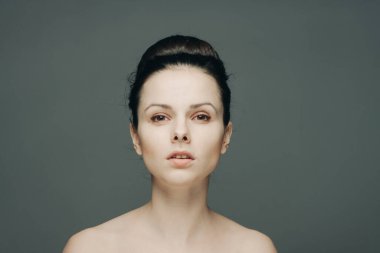 Çıplak omuzlu, güzel bir kadın. Açık tenli.