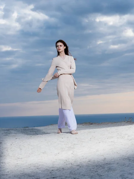 Μια γυναίκα περπατά όλα τα ρούχα της κοντά στη θάλασσα στα βουνά — Φωτογραφία Αρχείου