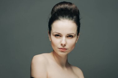 Esmer, çıplak omuzlu. Duyguları yüzünden okunuyor.