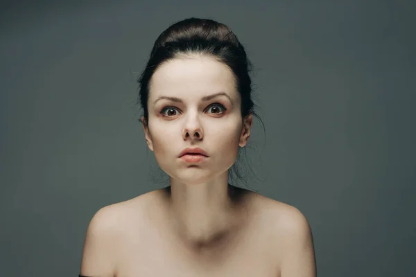 Женщина с голыми плечами на сером фоне чистой косметологии ухода за кожей красоты — стоковое фото