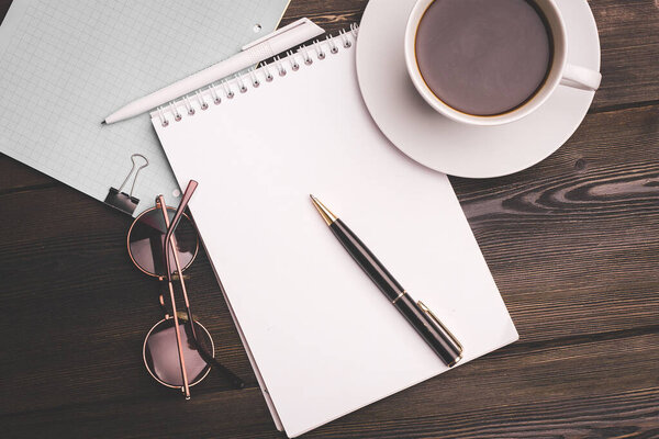 notebook with pen on wooden table coffee cup office business finance