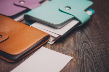 Masanın üzerinde kartvizit tutucu. Ahşap arka plan. Beyaz kağıt yaprağı.