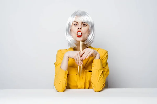 Attractive woman in white wig chopsticks sushi rolls restaurant — Stock Photo, Image