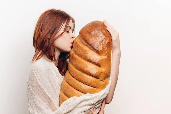 Donna con trucco luminoso abbracciando un grande pane nelle sue mani — Foto Stock