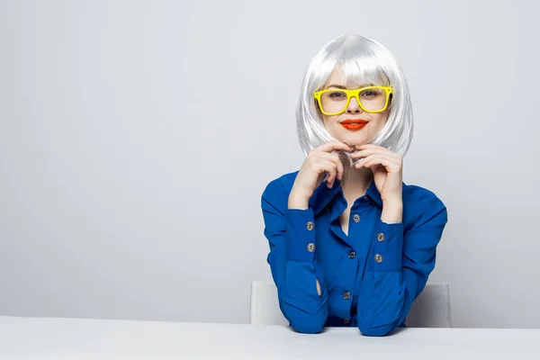 Aantrekkelijke vrouw in een witte pruik houdt handen in de buurt van het gezicht rode lippen charme gele bril — Stockfoto