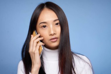 Koyu saçlı, Asyalı bir kadının portresi. Kahve, mavi arkaplan.