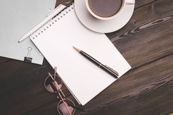 notebook with pen on wooden table coffee cup office business finance