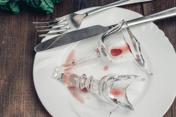 Rozbité sklo na talíři kuchyňské nádobí dřevěný stůl — Stock fotografie