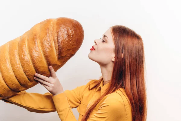 Mulher bonita com um pão em um fundo colorido modelo de emoções divertidas — Fotografia de Stock