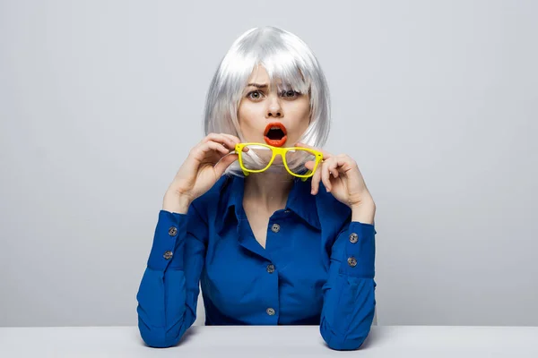 Alegre bonita mujer en una peluca blanca se sienta a la mesa rojo labios encanto — Foto de Stock