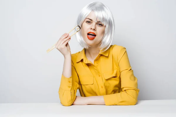 Atractiva mujer en peluca blanca comiendo sushi comida — Foto de Stock