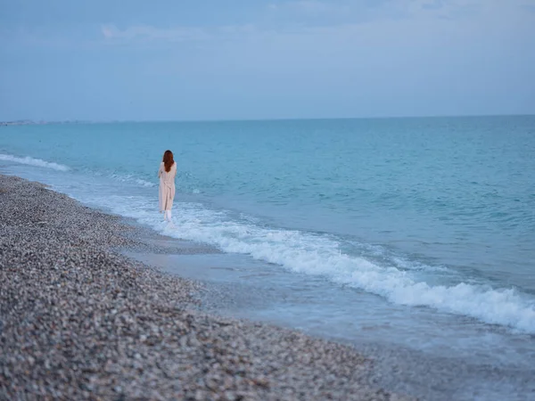 Mujer en suéter junto al océano y cielo azul con agua clara — Foto de Stock