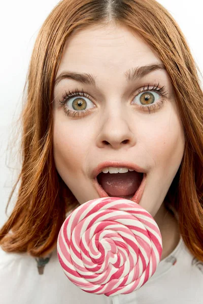 Zaskoczona kobieta z otwartymi ustami lizak w dłoni emocje cieszyć się deser — Zdjęcie stockowe
