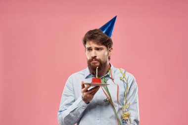 Pembe arka planda mumu olan pastalı bir adamın doğum günü.